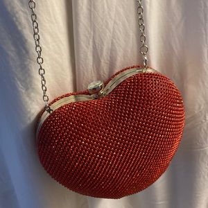 Red sparkly heart shaped handbag with silver strap and white crystal